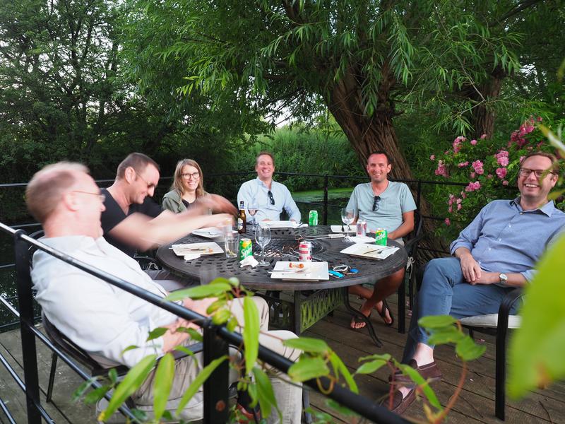 4 group members dining and chatting with Professor Andy Baldwin and Professor Justin Benesch at the Summer BBQ 2022