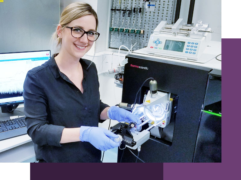 A photograph of Dr Corinne Lutomski  using the Orbitrap Eclipse, mass spectrometer.